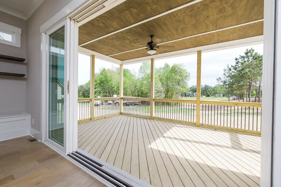 A veranda with tall glass doors opening the room to the outside