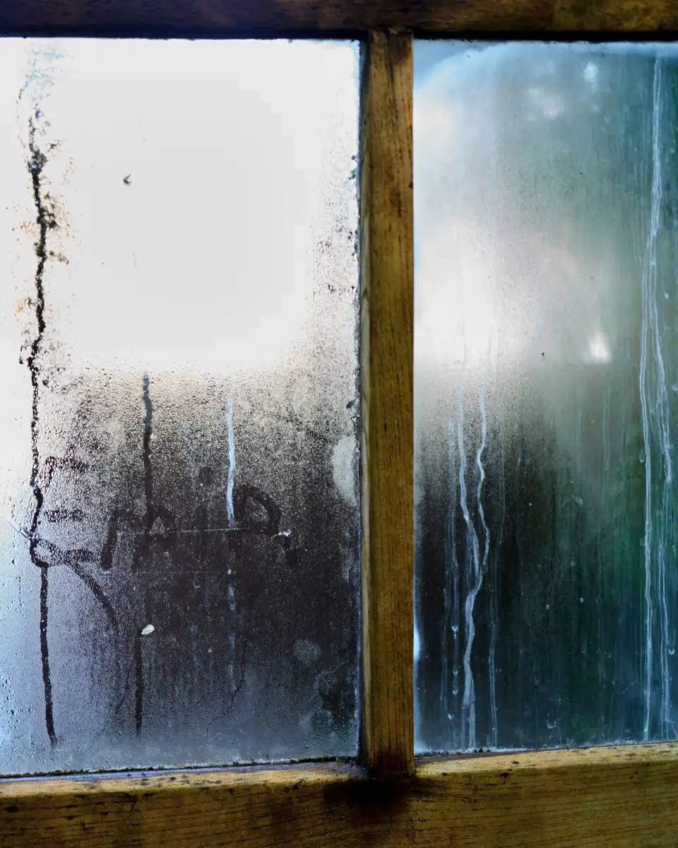 Condensation streaking the inside of an old window pane