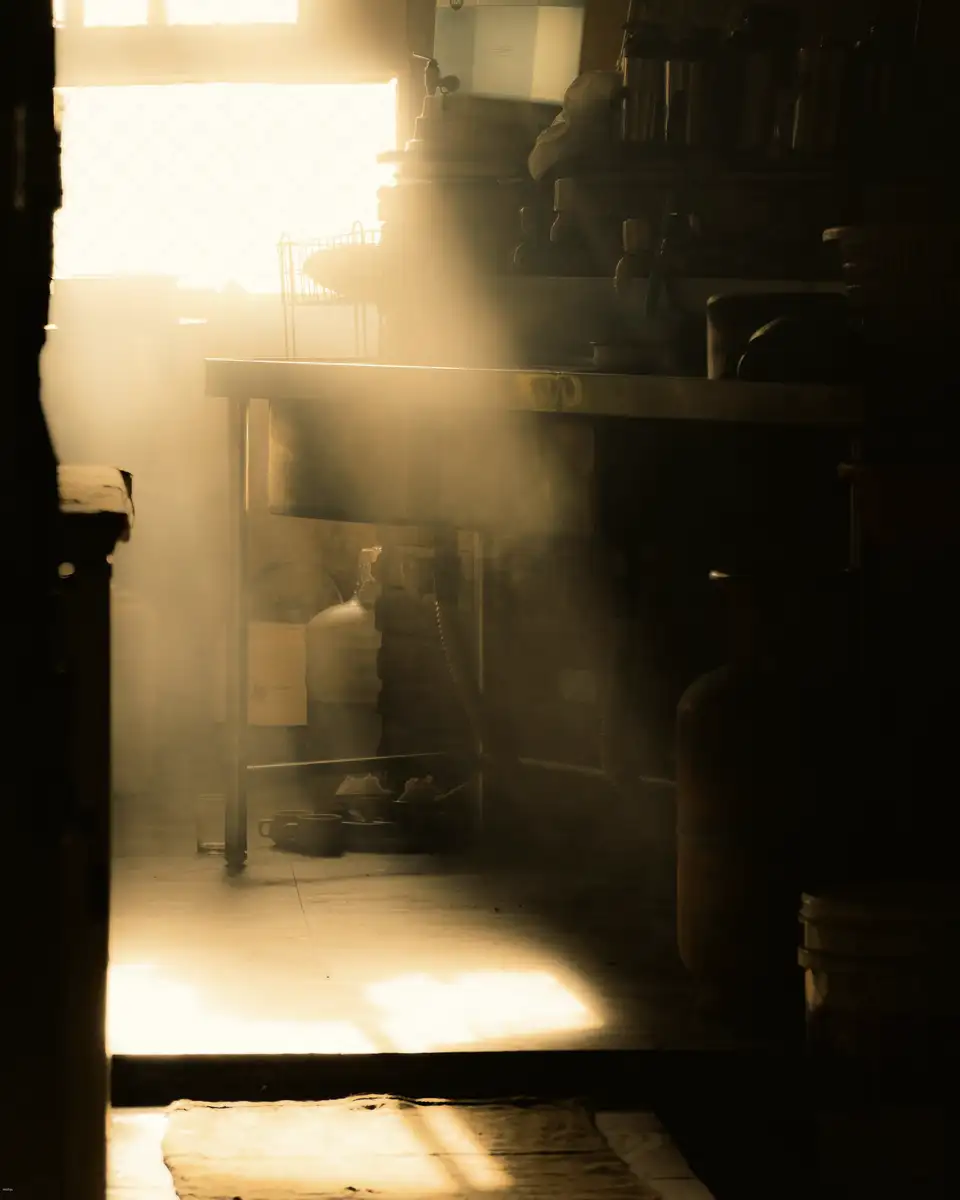Sunbeams through a kitchen window into a dim room
