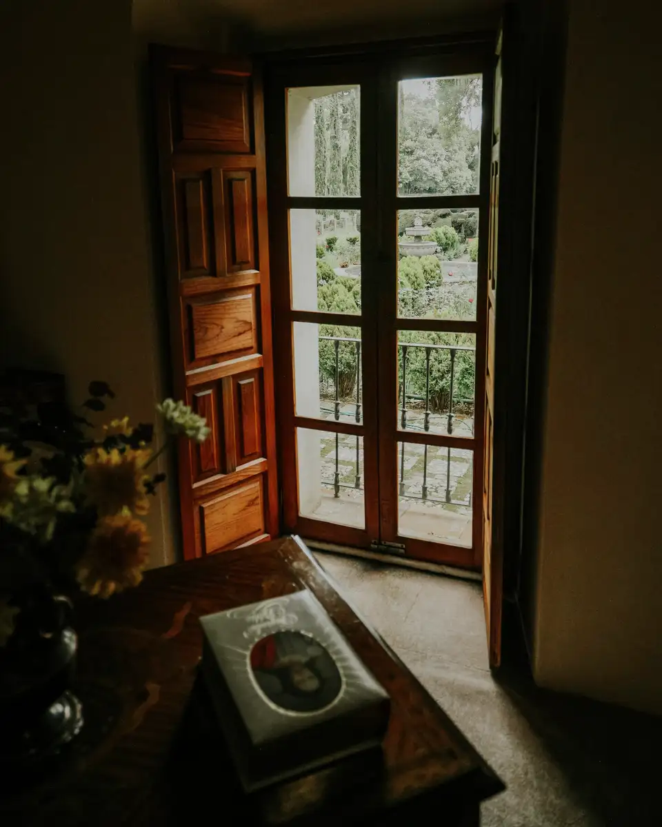 Wooden French doors open onto a garden in soft light